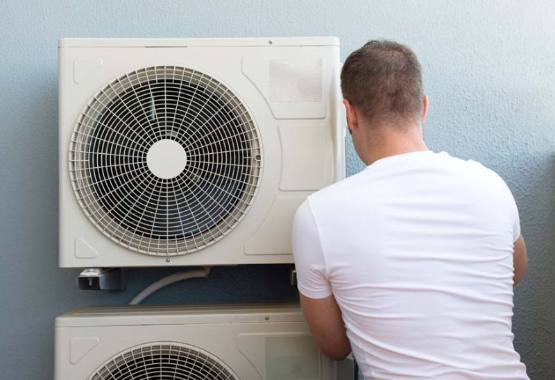 Male technician installing air-conditioning system.