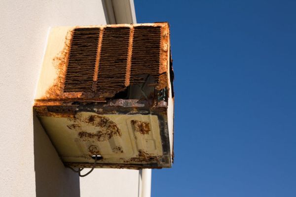 Image of old AC unit. Repairing or Replacing Your Air Conditioner.