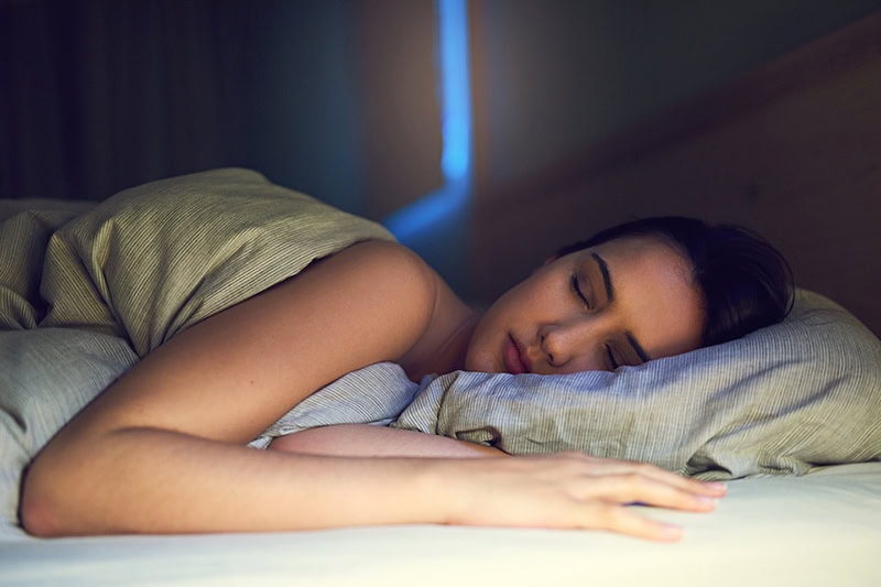 3 Health Benefits of Using Your AC While Sleeping. Photo of an elderly couple sleeping soundly in their bed.
