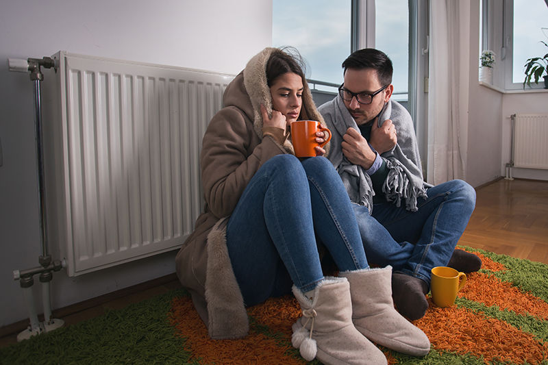 Cold Couple Huddled Next to Radiator