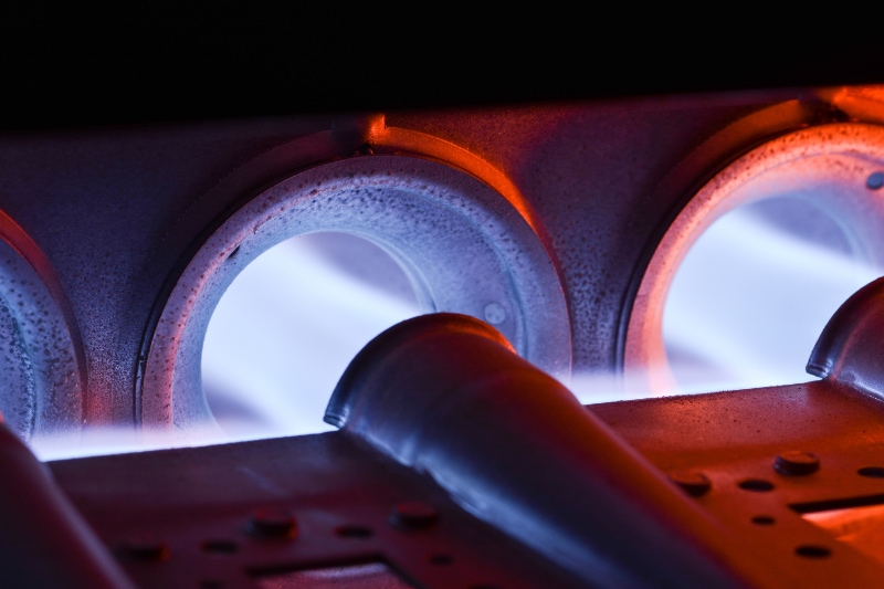 How Can I Make My Furnace Last Longer? Closeup Shot Of Home Furnace Burner Ignited With Crimson Blue Flame.