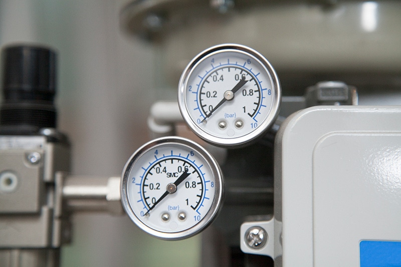 Heat Pump Versus Furnace. Photo of thermostats attached to HVAC machinery.