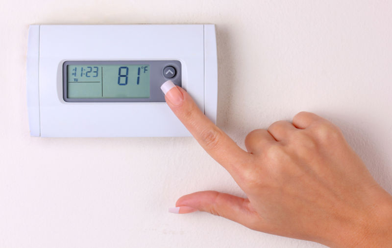 thermostat. woman's hand setting the wall heater