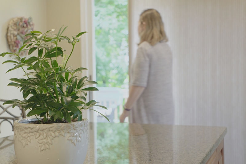 Woman Closing Blinds