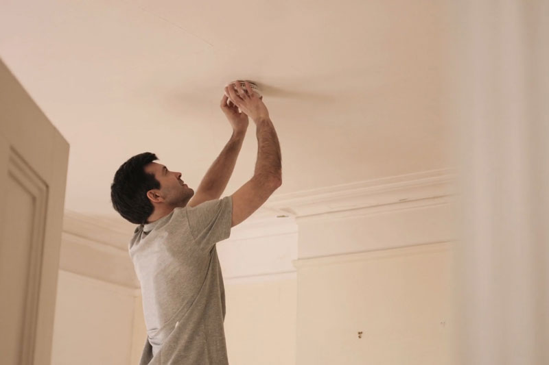 Video - When Do I Need to Replace the Batteries in My Smoke Detector? Man changing batteries in smoke detector.