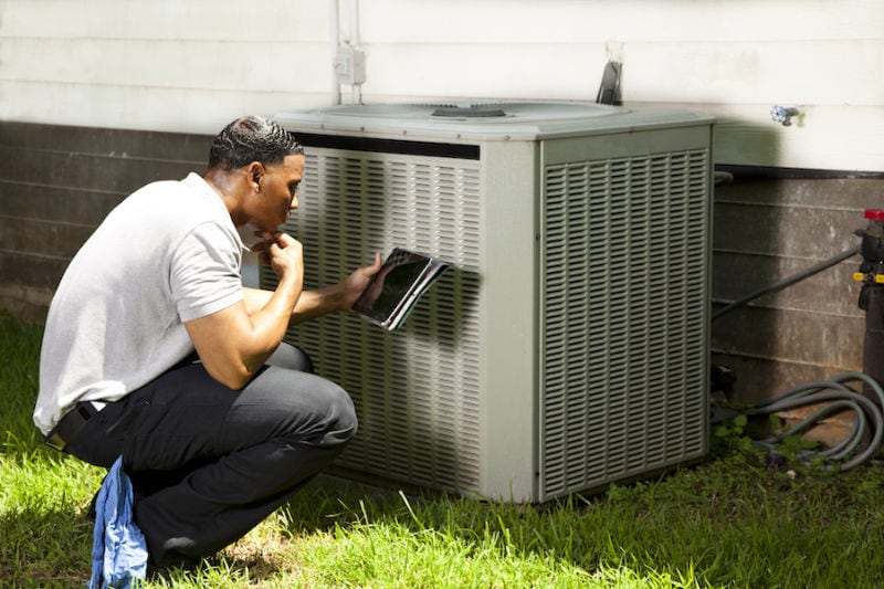 Home inspector, repairman uses digital tablet to check air conditioners. Home inspector, repairman uses digital tablet to check air conditioners.