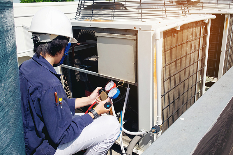 Why Is a Commercial AC Tune-Up Important? A technician working on a commercial air conditioning unit.