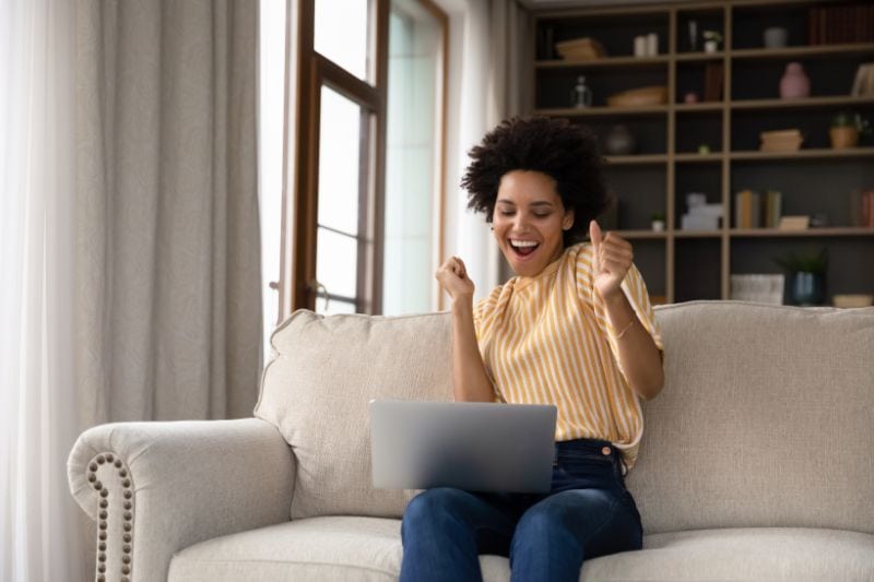 Image of person sitting on couch looking excited. Air Conditioners: Things You May Not Have Known.